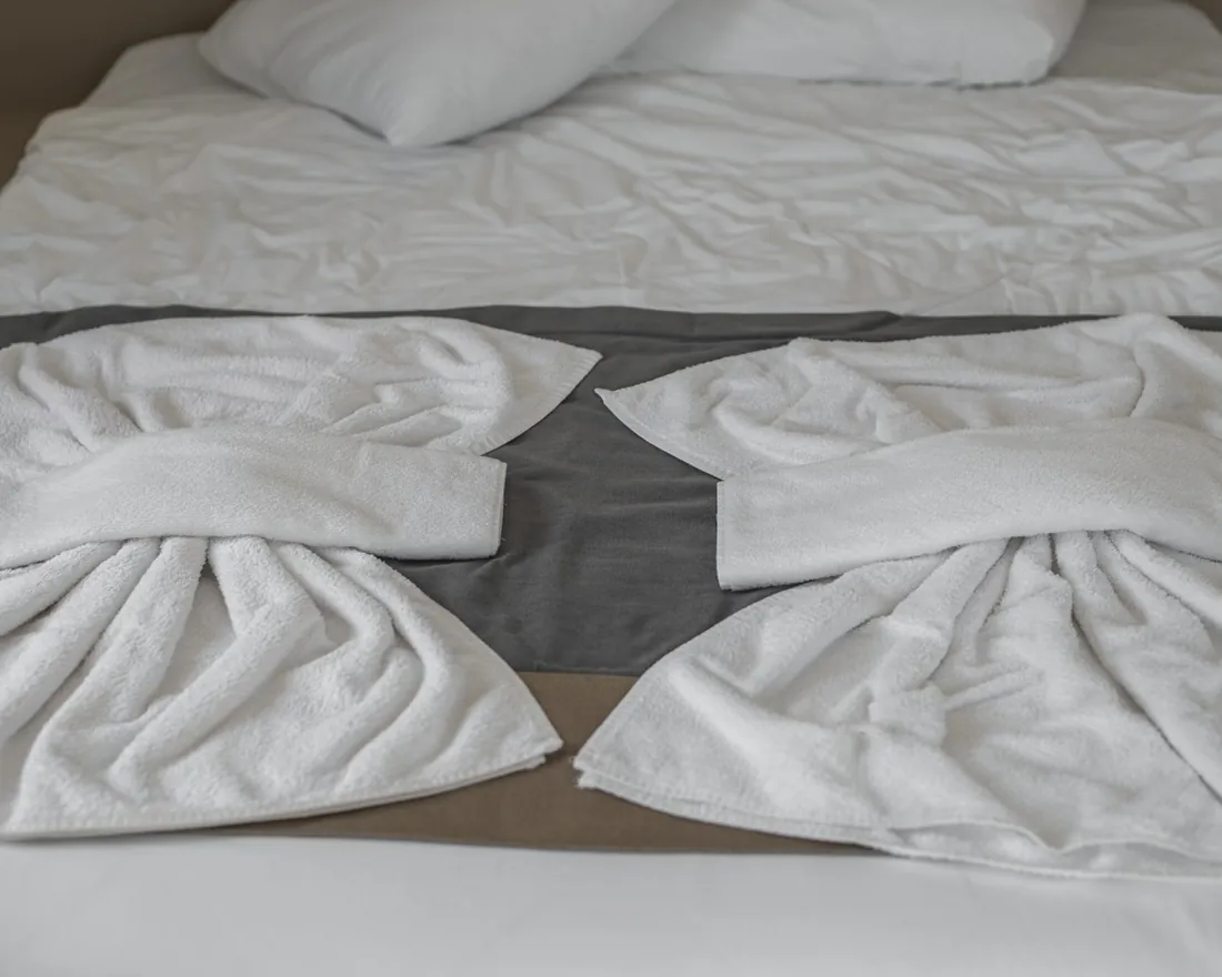 Toallas blancas sobre una cama de hotel